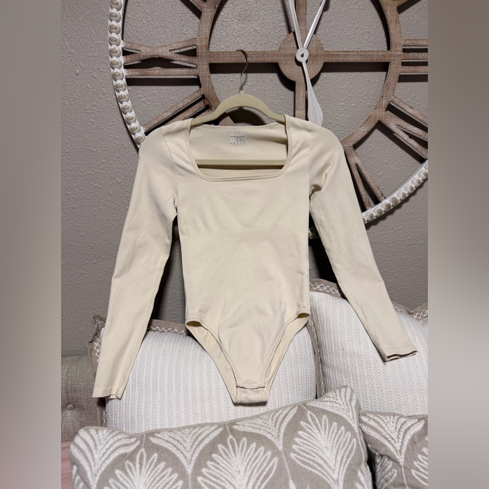 90% Nylon
10% Spandex 
Chic Beige Long Sleeve Bodysuit